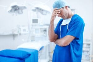 Sad, surgery and stress with man in hospital for patient loss, healthcare and frustrated